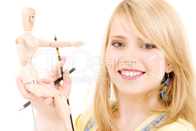 happy teenage girl with wooden model dummy