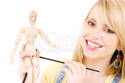 happy teenage girl with wooden model dummy