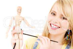 happy teenage girl with wooden model dummy