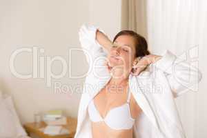 Morning bedroom - woman in bathrobe and bra