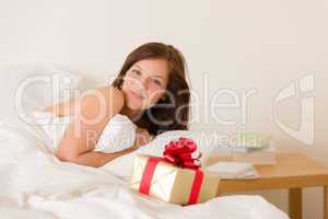 Bedroom surprise present - young happy woman