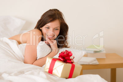Bedroom surprise present - young happy woman