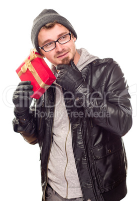 Warmly Dressed Young Man Holding Wrapped Gift To His Ear