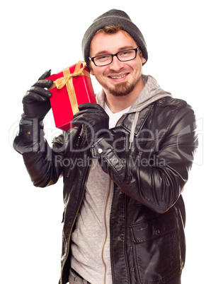 Warmly Dressed Young Man Holding Wrapped Gift To His Ear