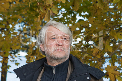 Portrait of middle-aged man in autumn day.