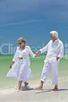 Happy Senior Couple Walking Holding Hands on A Tropical Beach