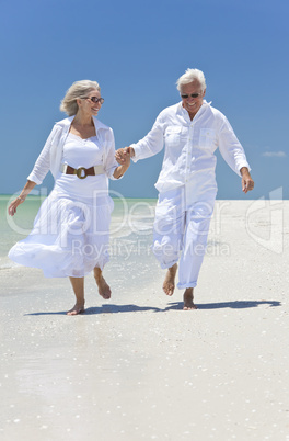 Happy Senior Couple Running Holding Hands on A Tropical Beach