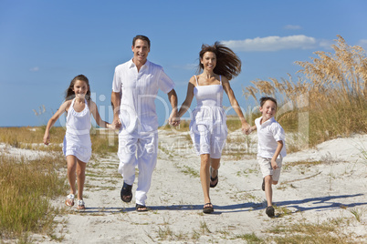 Mother, Father and Children Family Running Having Fun At Beach