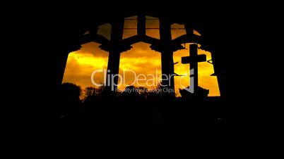 Looking at graveyard through derelict arched church windows