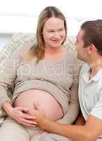 Lovely pregnant woman touching her belly with her husband