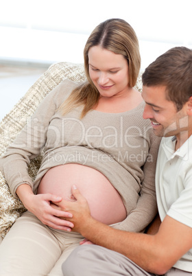 Beautiful future parents feeling their unborn child sitting in t