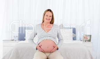 Joyfull pregnant woman in her bedroom