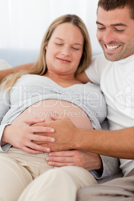 Portrait of future parents feeling their baby