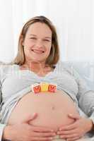 Adorable future mother with mom letters on her belly