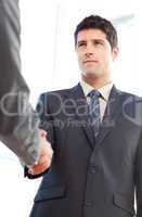 Below view of a serious businessman concluding a deal with a par