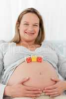 Adorable blond woman with mom letters on her belly