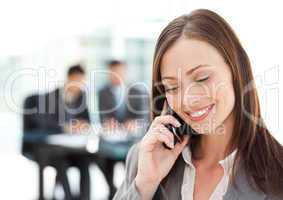 Pretty businesswoman on the phone while her team is working