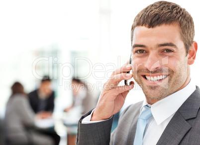 Handsome businessman on the phone in the foreground