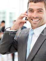 Cheerful businessman on the phone during a meeting with his team