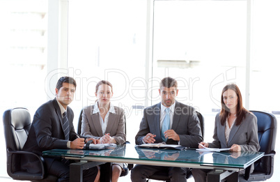 Rear view of a businesswoman being interviewed by three executives sitting around a table