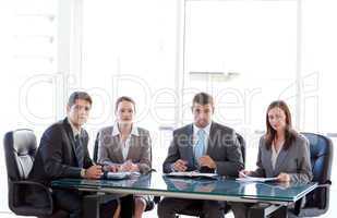 Rear view of a businesswoman being interviewed by three executives sitting around a table