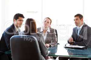Rear view of a businesswoman being interviewed by three executiv