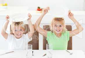 Funny brother and sister asking for their lunch raising their pl