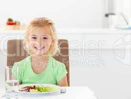 Portrait of a cute girl eating a healthy salad for lunch