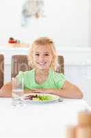 Smart girl sitting at a table to eat her healthy salad