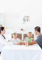 Family holding their hands while praying before eating a salad