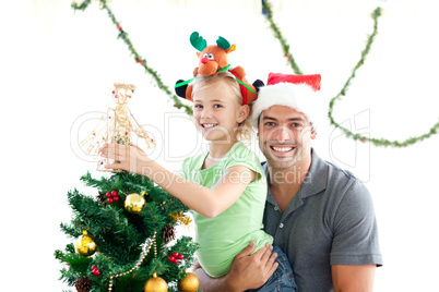 Happy father and daughter decorating together the christmas tree