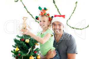 Happy father and daughter decorating together the christmas tree