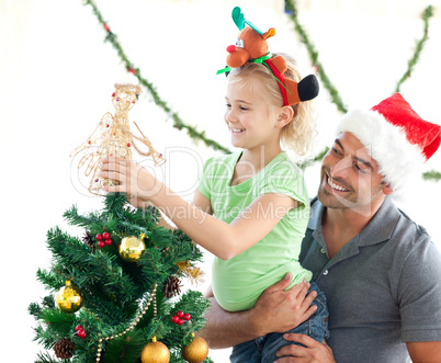 Cute little girl decorating the christmas tree with her father