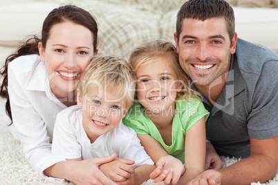 Adorable family sitting on the sofa and smiling at the camera