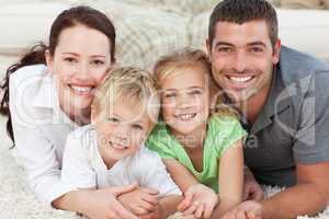 Adorable family sitting on the sofa and smiling at the camera