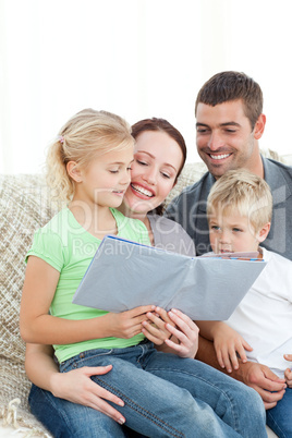 Adorable family reading a book together in the living-room