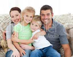 Adorable family sitting on the sofa and smiling