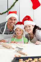 Cheerful family kneading biscuits for Christmas