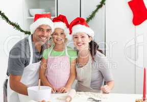 Portrait of a man with wife and daughter cooking Christmas biscu