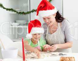 Lovely mother and daughter preparing Christmas cookies