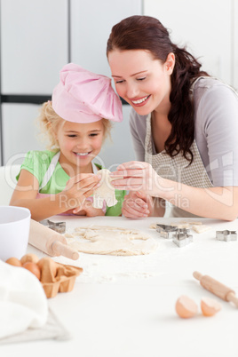 Cheerful mother and daughter making cookies in form of a man