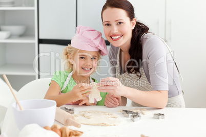 Cute daughter and mother showing a cookie in form of a man