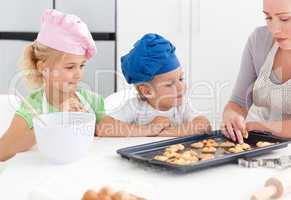 Siblings and their mother tasting their biscuits