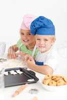 Adorable siblings kneading together a dough in the kitche