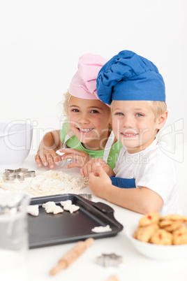 Two little chefs preparing cookies in the kitchen