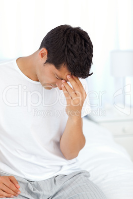 Attractive man having a headache and touching his forehead