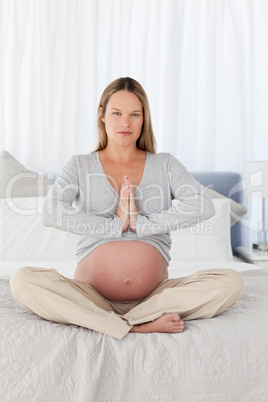 Serious pregnant woman doing yoga