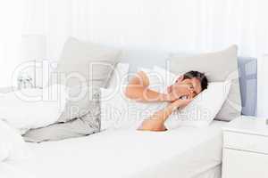 Sick man blowing his nose lying on his bed