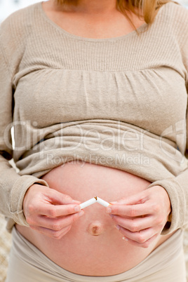Good pregnant woman breaking a cigarette