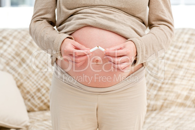 Close up of a pregnant woman breaking a cigarette